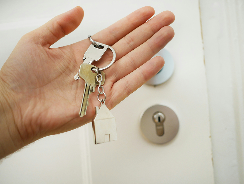 Handing over house keys, representing real estate tax challenges